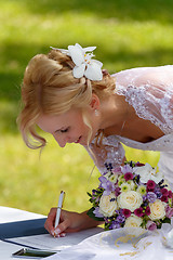 Image showing beautiful blonde smiling bride signed contract