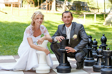 Image showing beautiful young wedding couple and outdoor chess