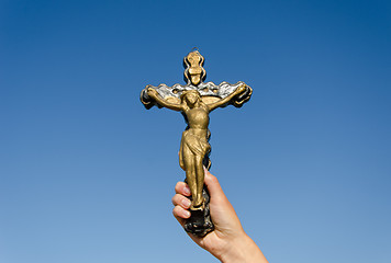 Image showing metal cross crucified christ in hand on blue sky  