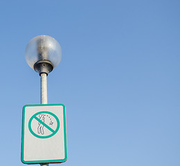 Image showing warning sign on littering streets on street lamp 