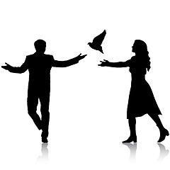 Image showing Concept of love or peace. Silhouettes girl and guy released dove