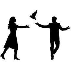 Image showing Concept of love or peace. Silhouettes girl and guy released dove