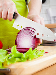 Image showing Woman's hands cutting bulb onion