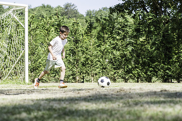 Image showing Child playing football in a stadium