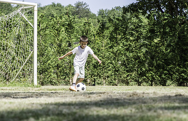 Image showing Child playing football in a stadium