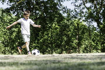 Image showing Child playing football in a stadium