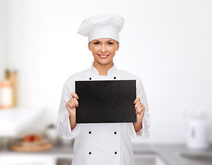 Image showing smiling female chef with black blank paper