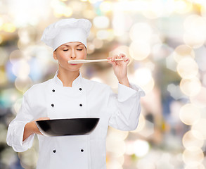 Image showing smiling female chef with pan and spoon