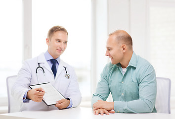 Image showing doctor with clipboard and patient in hospital