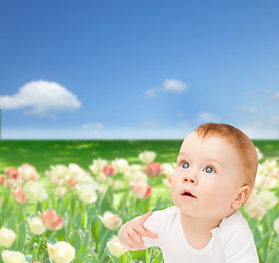 Image showing curious baby lying on floor and looking up