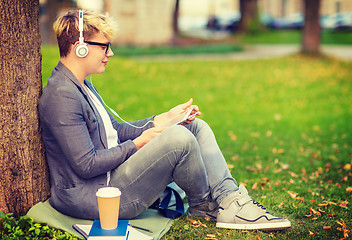 Image showing boy with headphones, tablet pc, books and coffee