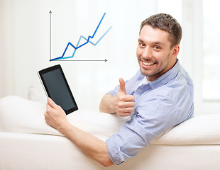 Image showing smiling man working with tablet pc at home