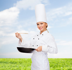 Image showing smiling female chef with pan and spoon