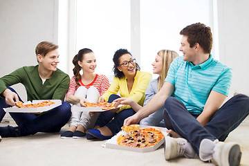 Image showing five smiling teenagers eating pizza at home