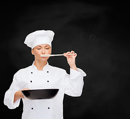 Image showing smiling female chef with pan and spoon