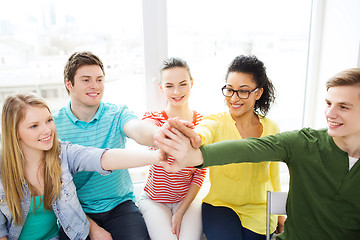 Image showing smiling students making high five gesture sitting