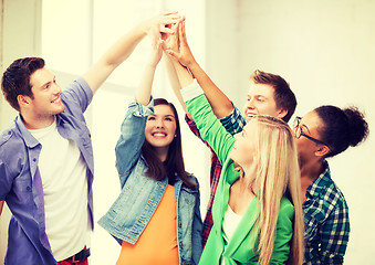 Image showing happy students giving high five at school