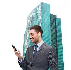 Image showing young smiling businessman with smartphone