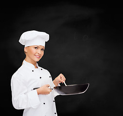 Image showing smiling female chef with pan and spoon