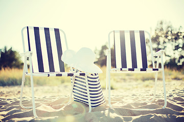 Image showing two beach lounges with beach bag and white hat