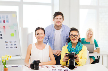 Image showing smiling team with photocamera working in office