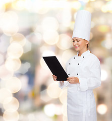 Image showing smiling female chef with black blank paper