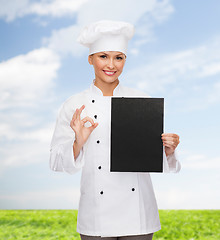 Image showing smiling female chef with black blank paper