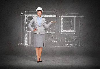 Image showing businesswoman in helmet holding something on palm