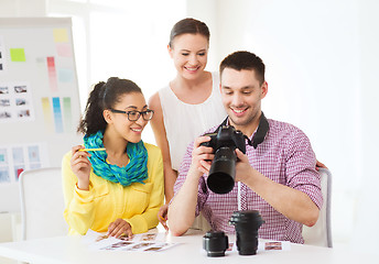 Image showing smiling team with photocamera working in office