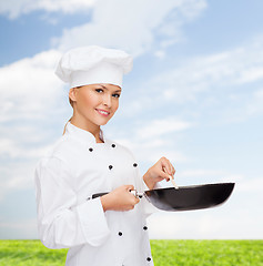 Image showing smiling female chef with pan and spoon