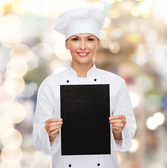 Image showing smiling female chef with black blank paper