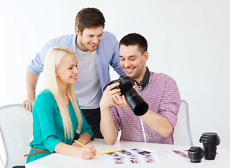 Image showing smiling team with photocamera working in office