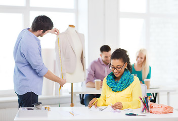 Image showing smiling fashion designers working in office