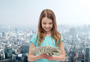 Image showing smiling little girl looking at dollar cash money