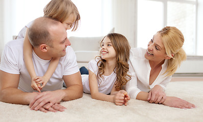 Image showing parents and two girls lying on floor at home