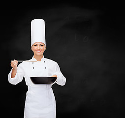 Image showing smiling female chef with pan and spoon