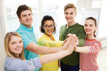 Image showing five smiling students giving high five at school