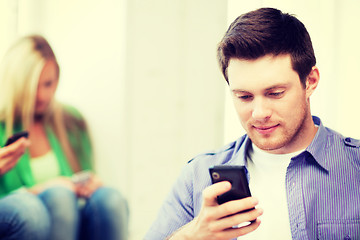 Image showing student looking at phone and tiping