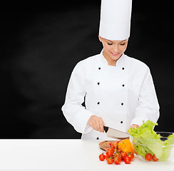 Image showing smiling female chef chopping vegetables