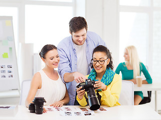 Image showing smiling team with photocamera working in office