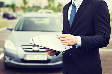 Image showing man with car documents outside