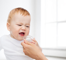 Image showing crying baby with dummy