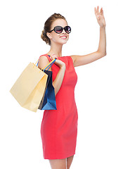 Image showing smiling elegant woman in dress with shopping bags