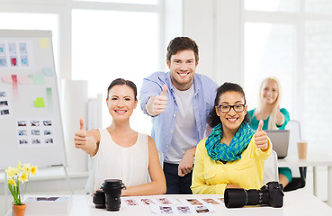 Image showing smiling team with photocamera in office