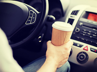 Image showing man drinking coffee while driving the car