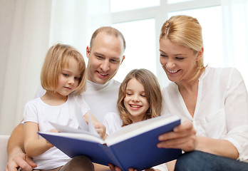 Image showing smiling family and two little girls with book