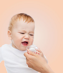 Image showing crying baby with dummy