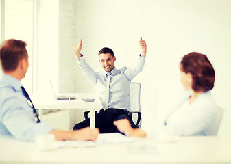 Image showing happy businessman showing thumbs up in office