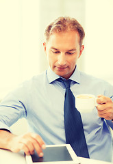 Image showing businessman with tablet pc and coffee in office