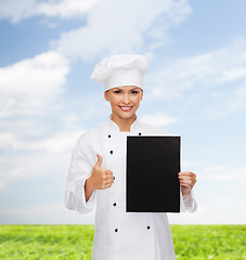 Image showing smiling female chef with black blank paper